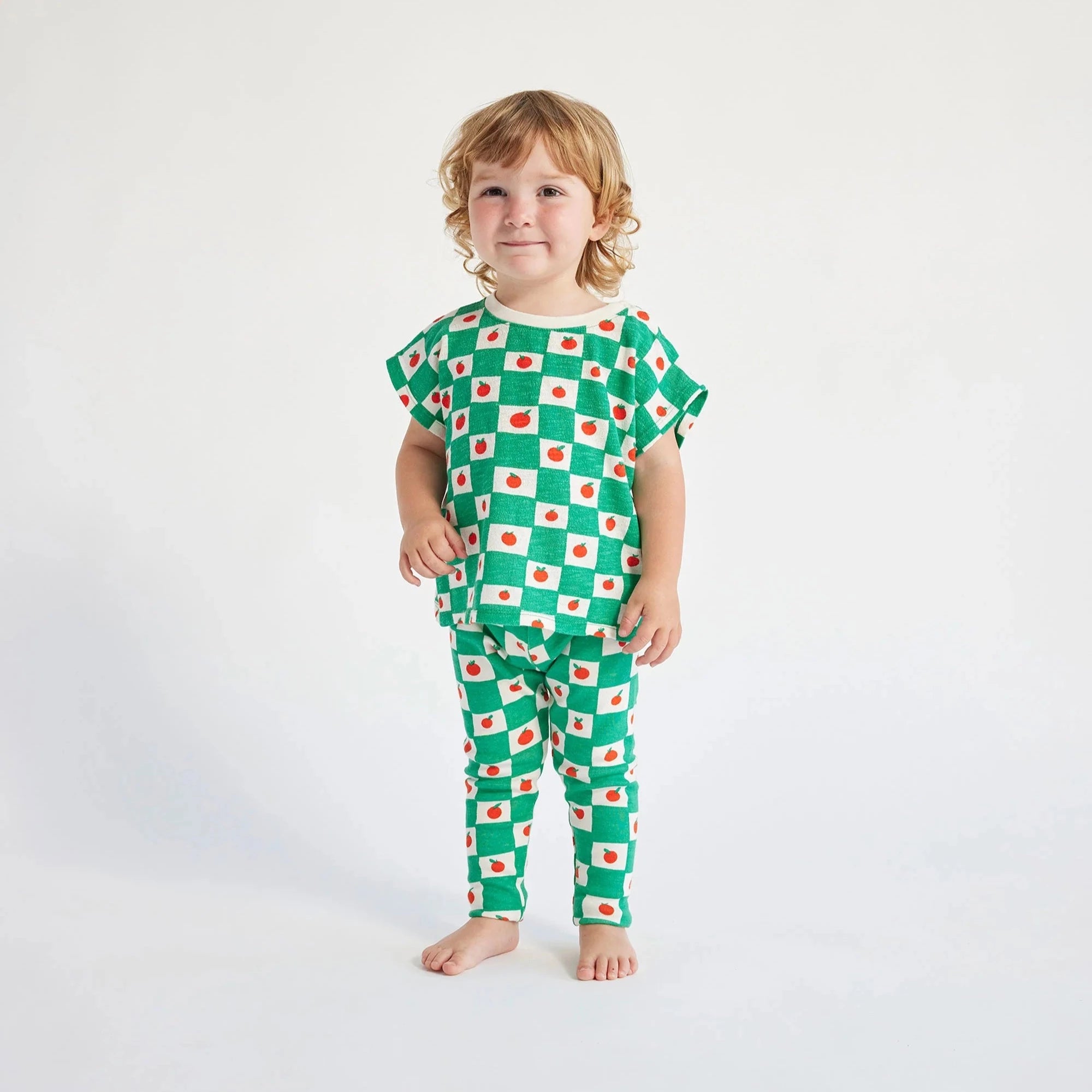 child wearing green and white checked t-shirt with tomato print