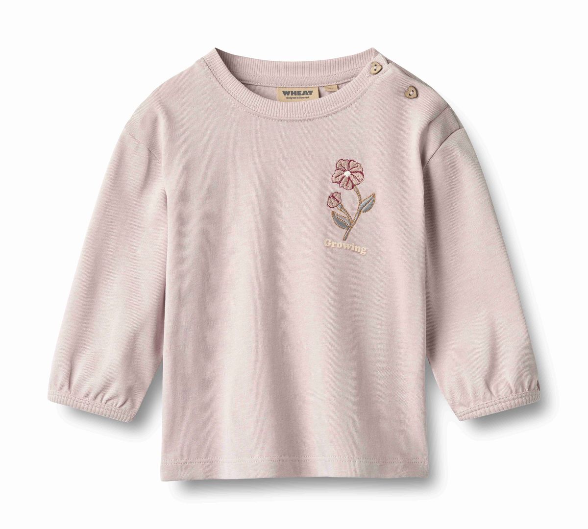 A light pink long-sleeve baby top, featuring a small embroidered flower on the left chest with the word 'dreaming' below it, set against a plain white background.