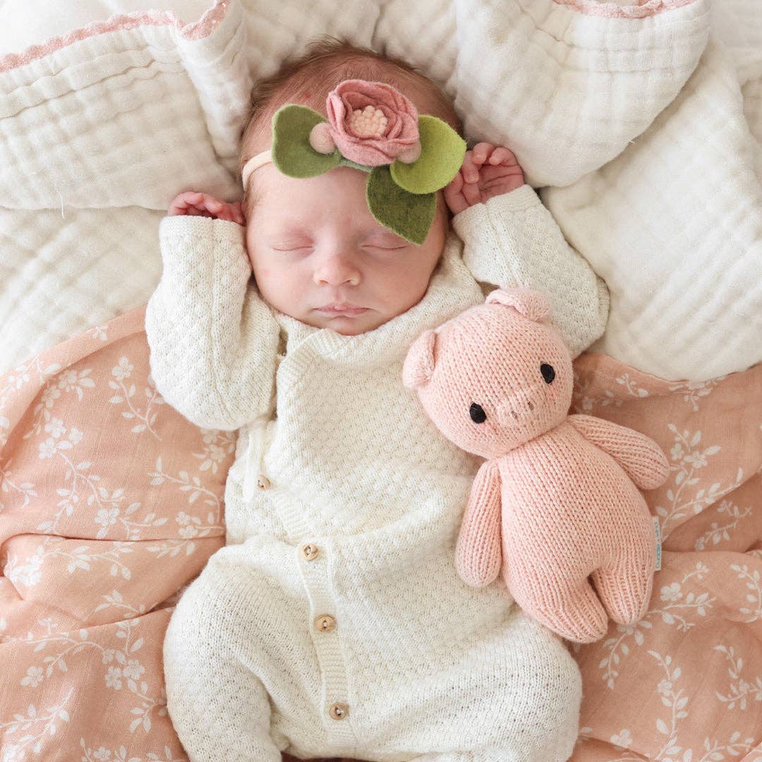 Knitted pink pig toy on a white background