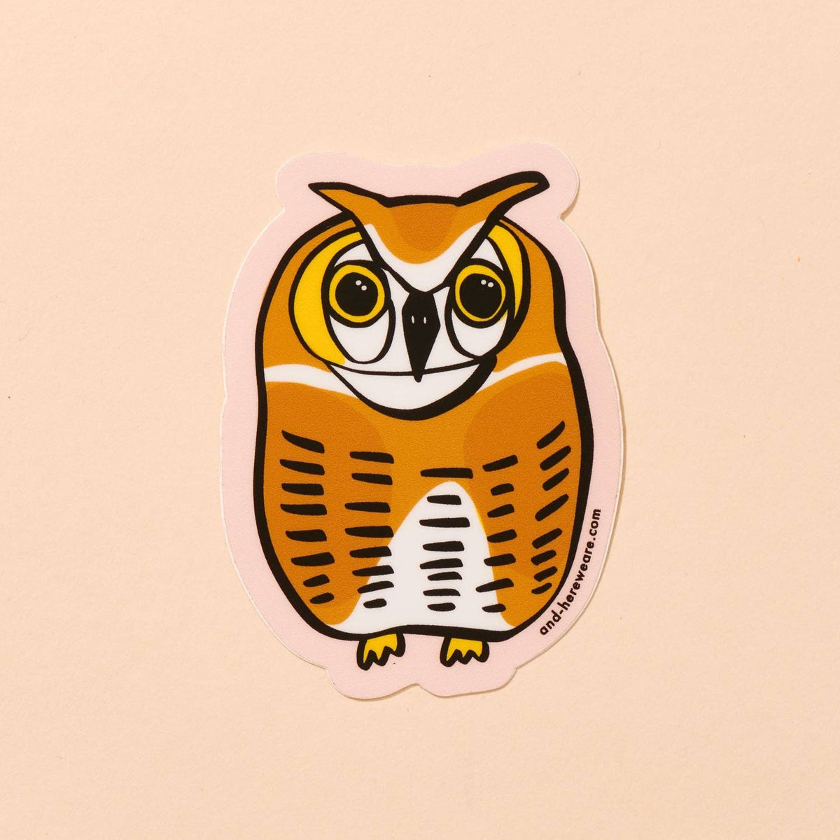 An owl-shaped sticker featuring a stylized orange and white owl with black outlines, shown on a solid pale peach background.
