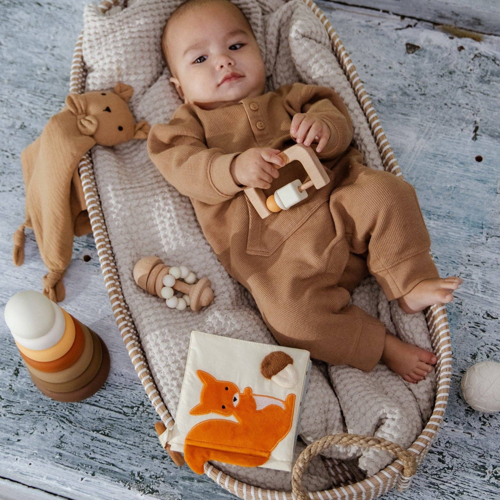 Baby product set with a fox design in a cardboard box on a beige background