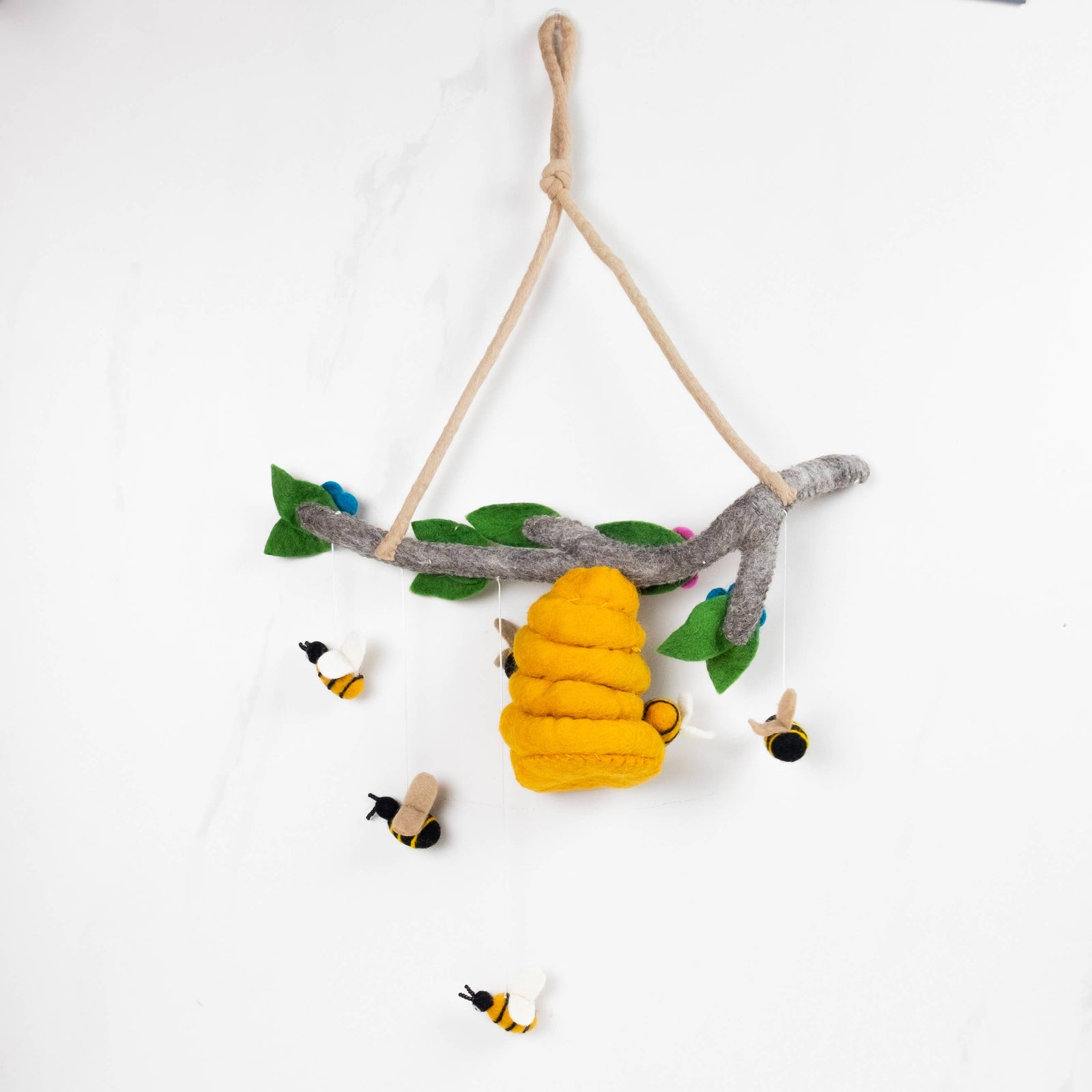 Children's mobile with bee and flower decorations on a white background
