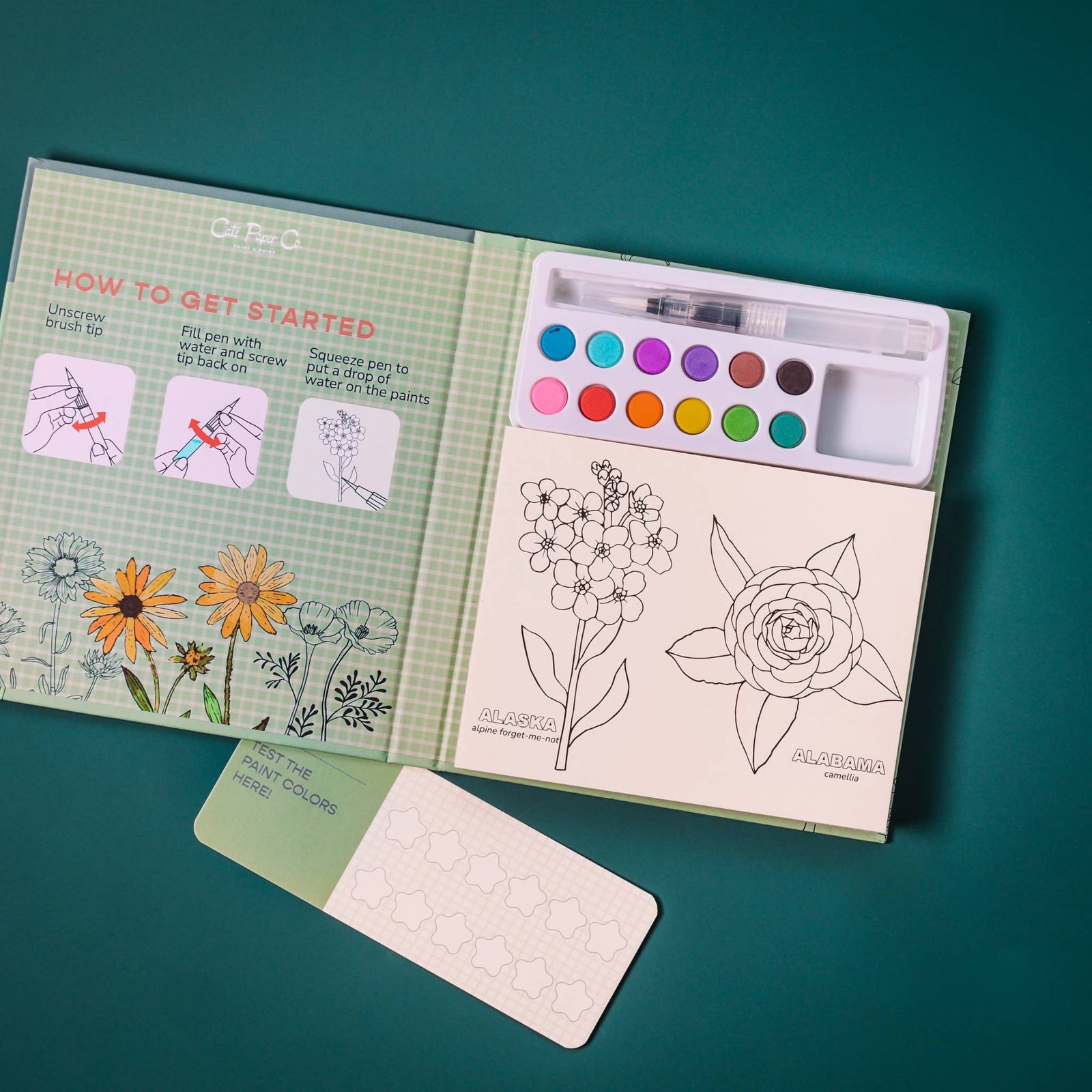 Watercolor painting book with floral illustrations on a teal background