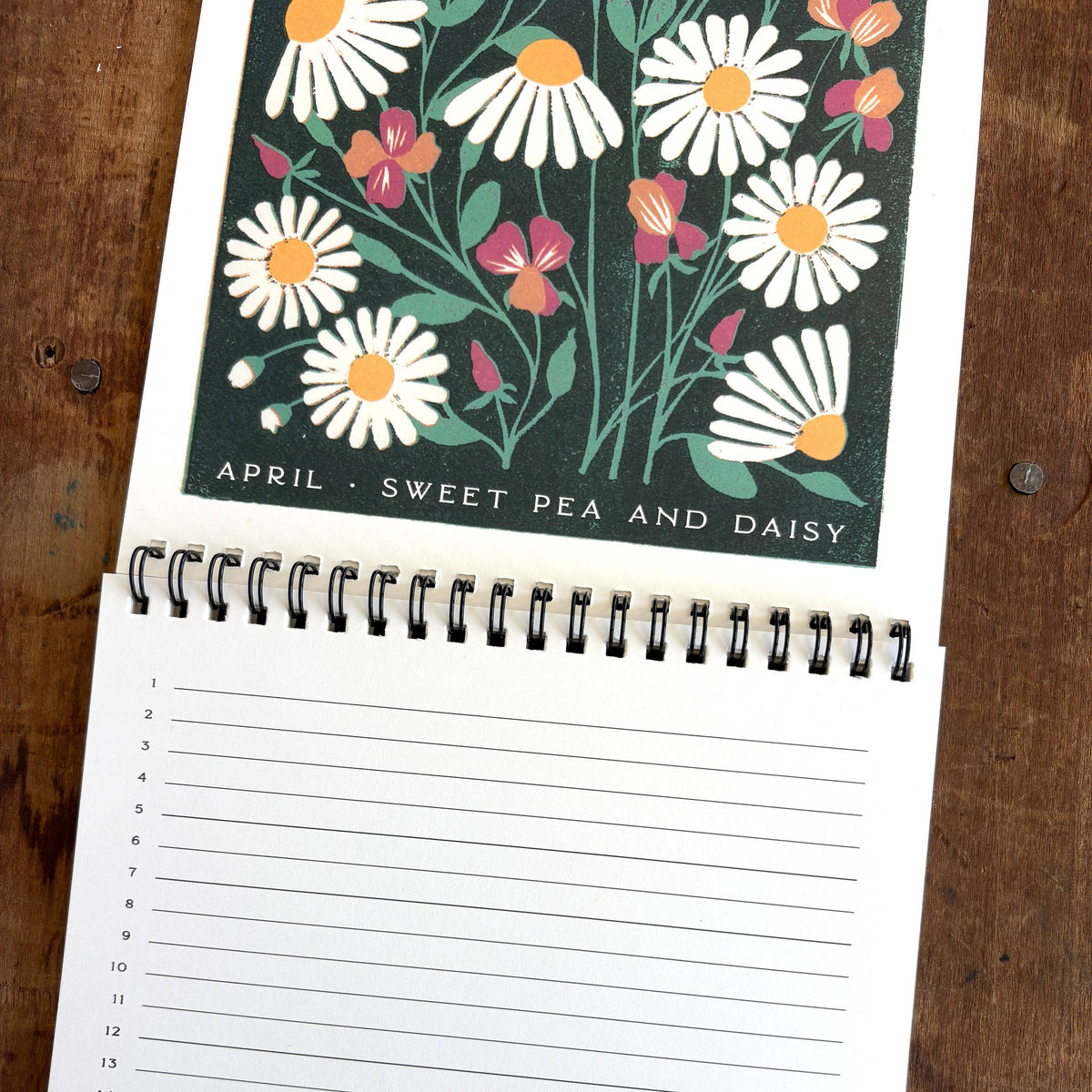 Notebook with floral design on the cover and lined pages on a wooden surface