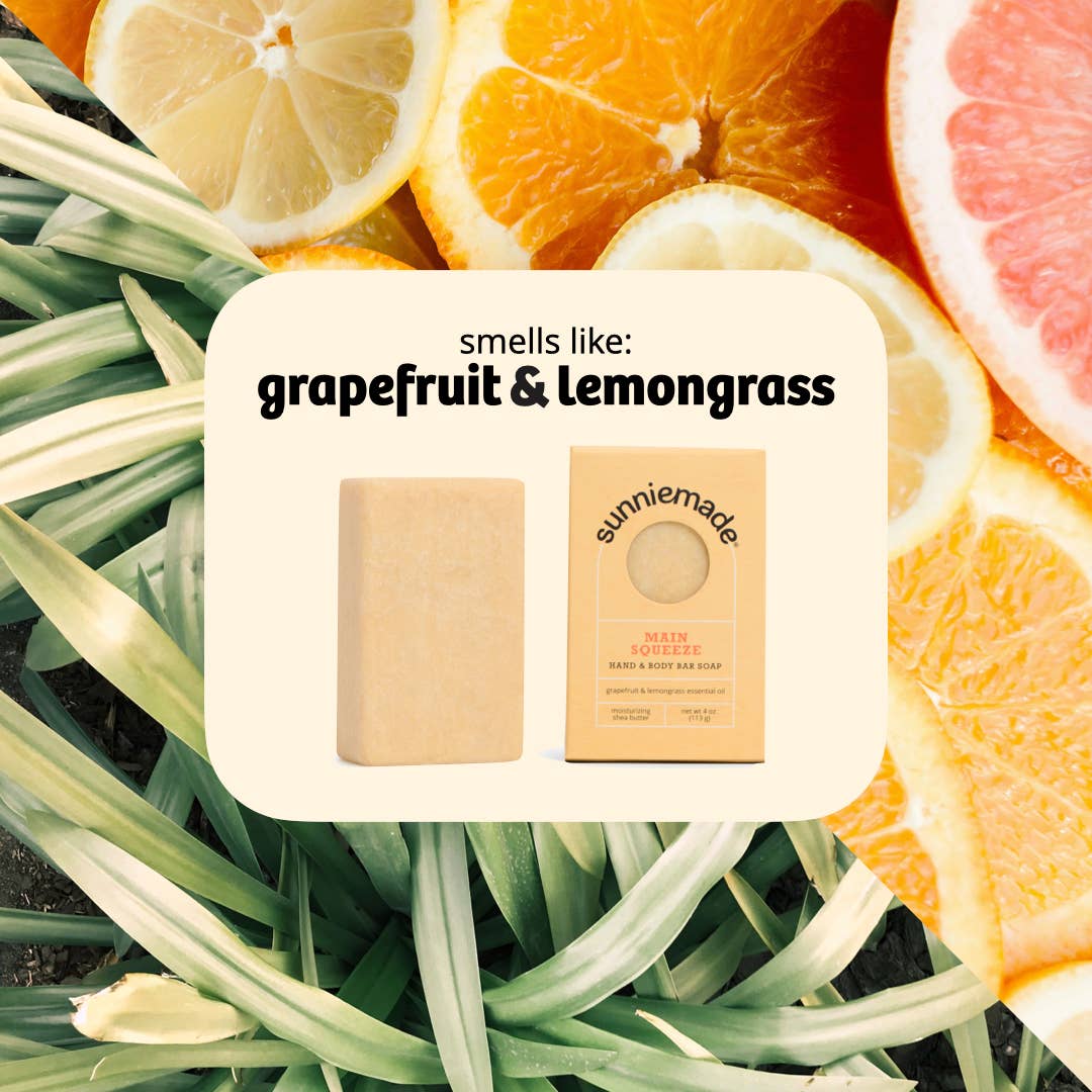 Sunniemade soap bars with grapefruit and lemongrass scent on a background of citrus fruits and grass.
