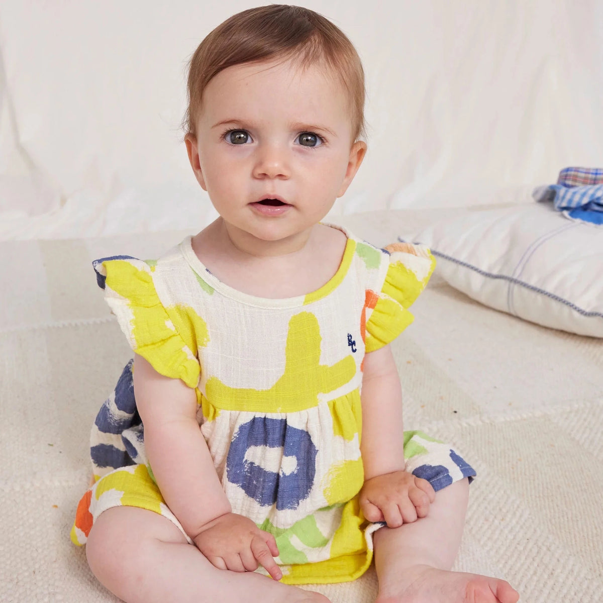 child sitting in dress