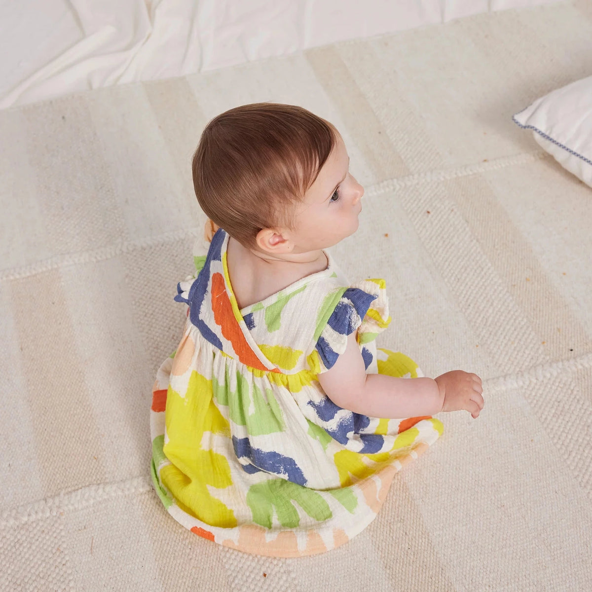 child sitting with back view of dress