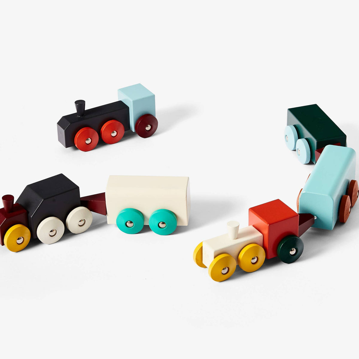 Set of colorful wooden toy trains on a white background