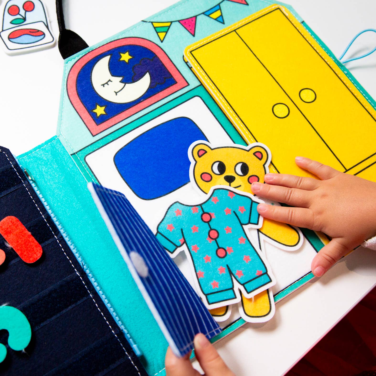 A colorful Montessori play kit bag with various activity cards and a yellow label that reads 'Montessori Play Kit - My Day'.