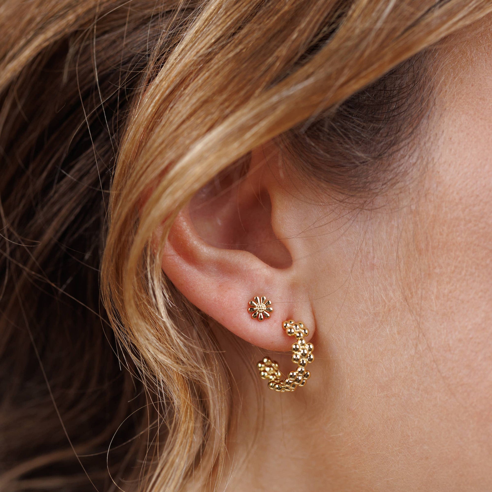 Gold hoop earrings on a Jax Kelly branded card against a beige background