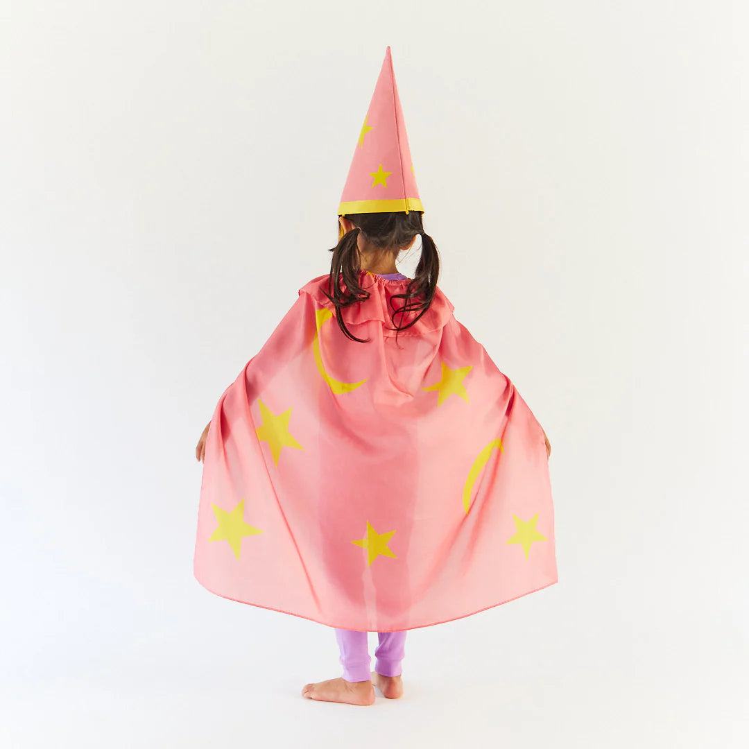 Child wearing a pink wizard costume with yellow stars and a pointed hat on a white background