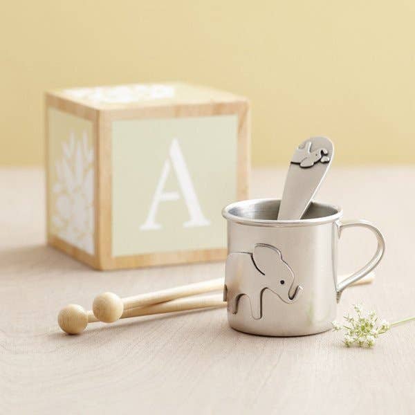 pewter elephant cup next to wooden block