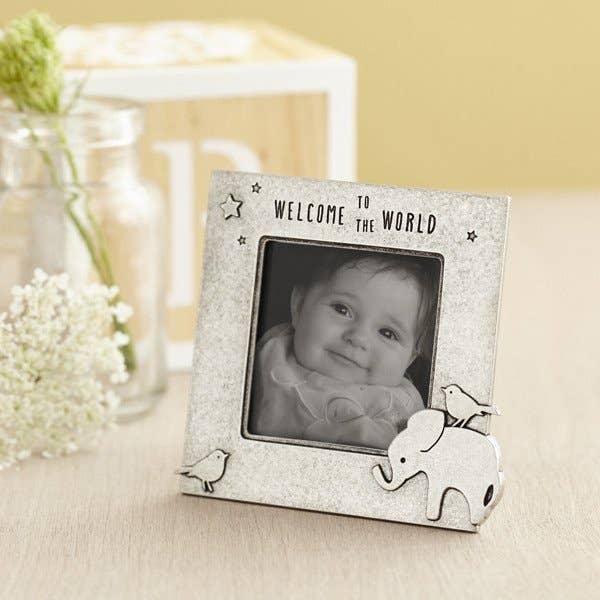 pewter elephab=nt picture frame next to wooden block