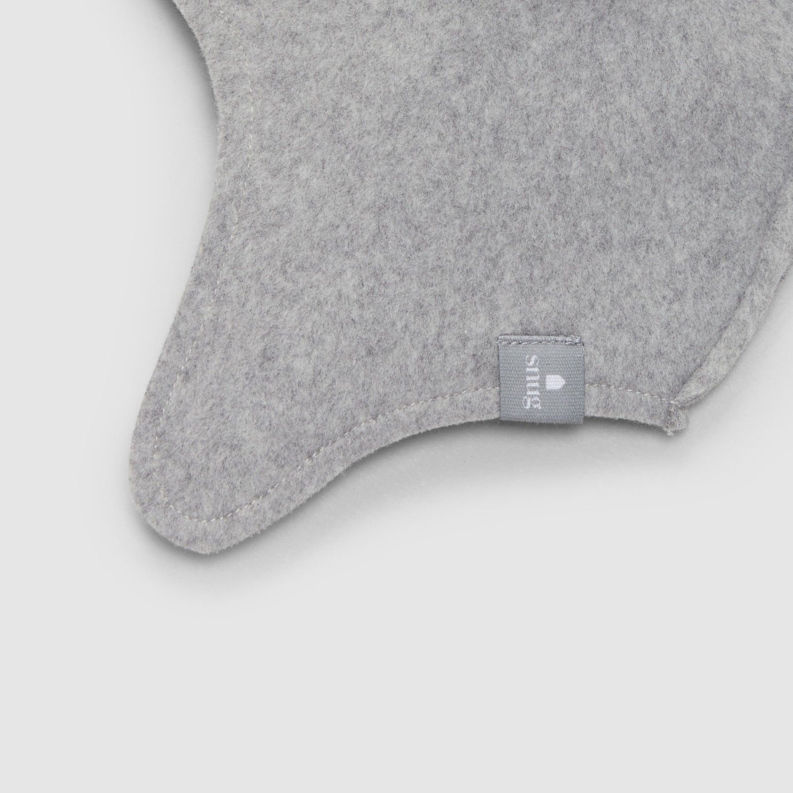 Gray baby hat with ear flaps on a light gray background