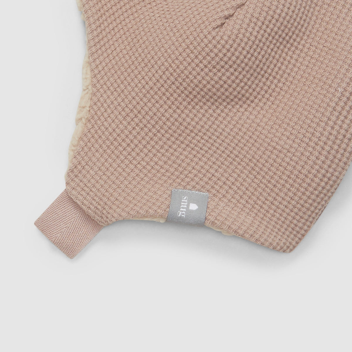 Textured pink hat with a snug label on a white background