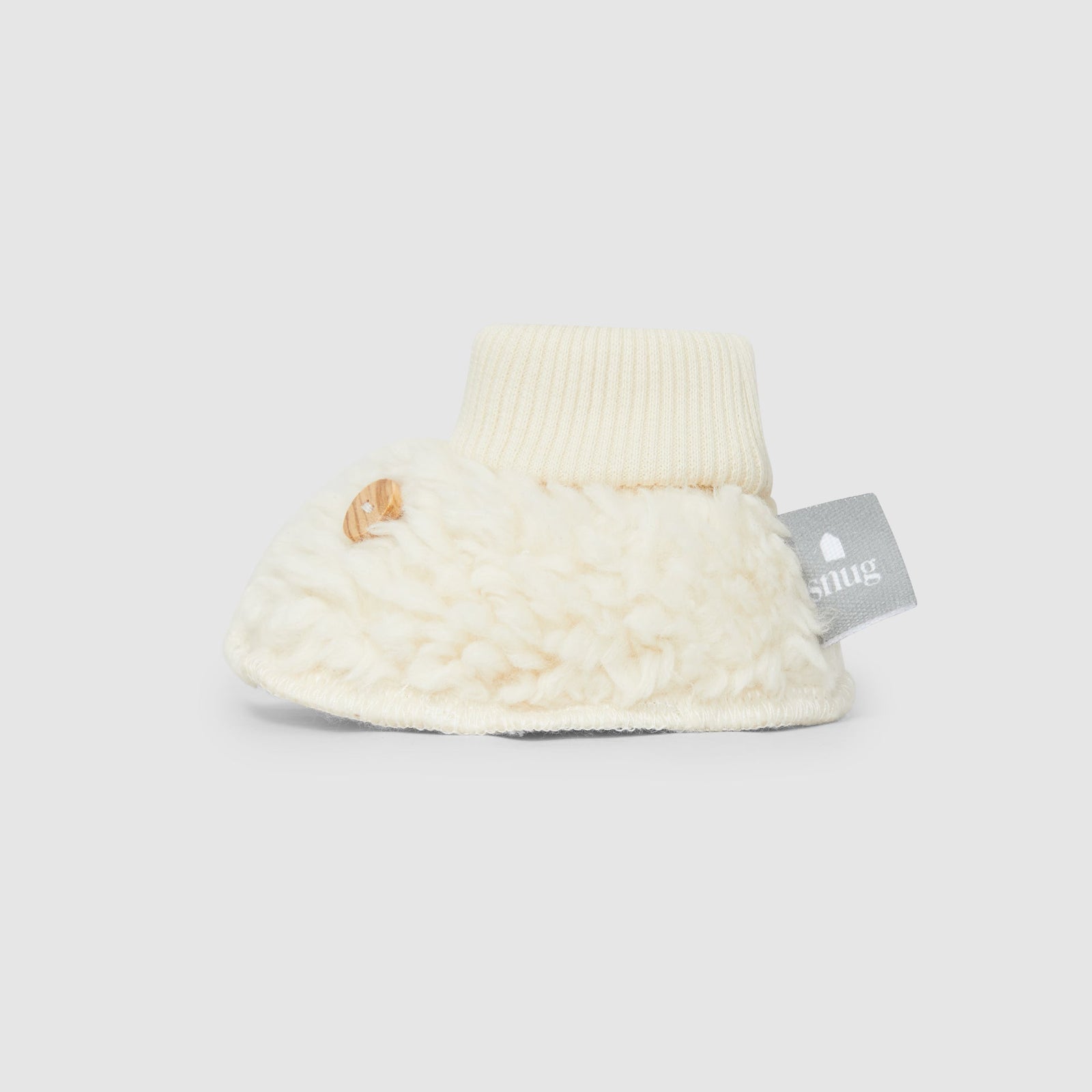 Pair of cream-colored baby booties on a white background