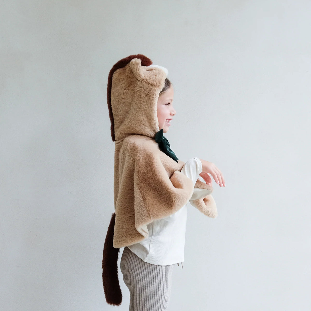 Person wearing a brown animal hooded cloak with a white background