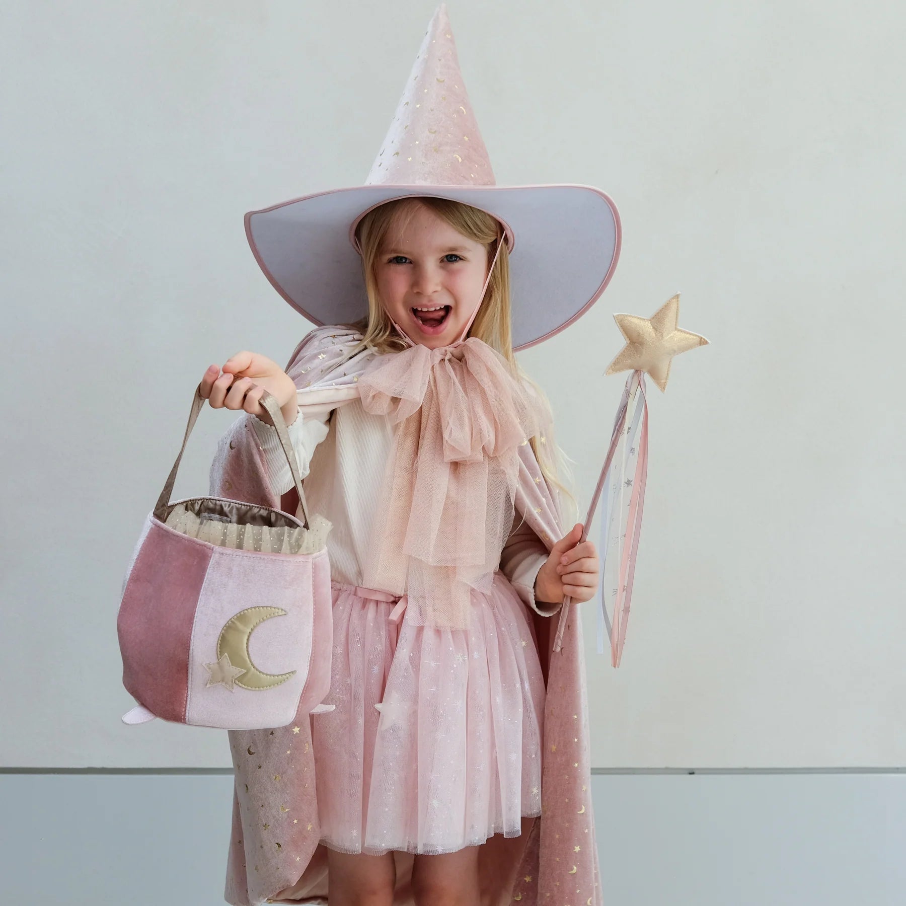 Pink cape with star pattern and bow on a white background