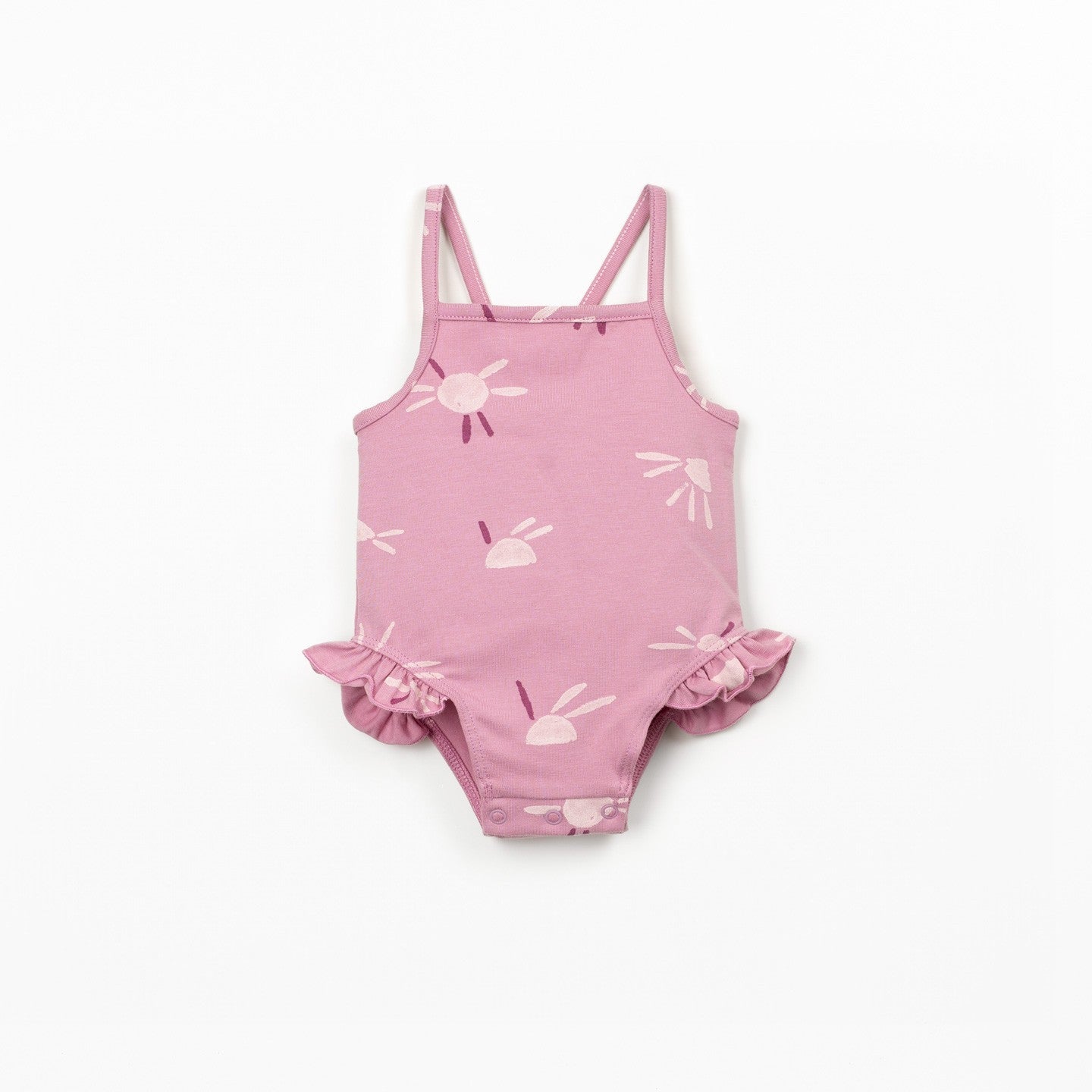 Child wearing a pink swimsuit standing on a white background