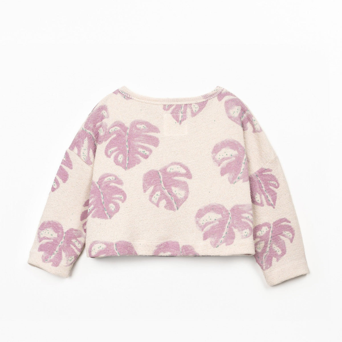 White sweater with pink leaf pattern on a white background