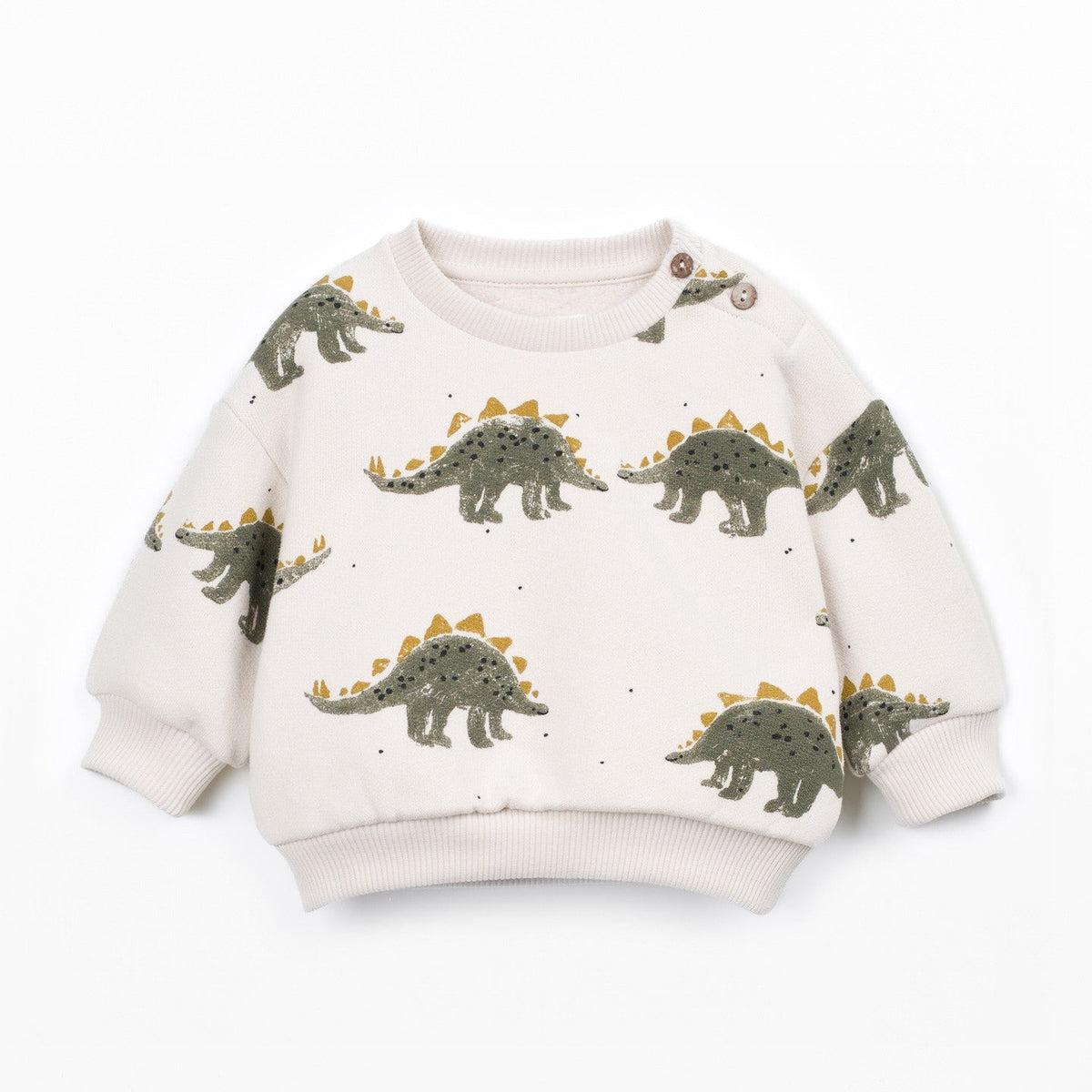 A long-sleeve knit sweater in cream with an all-over print of green and yellow dinosaurs, shown flat on a white background.