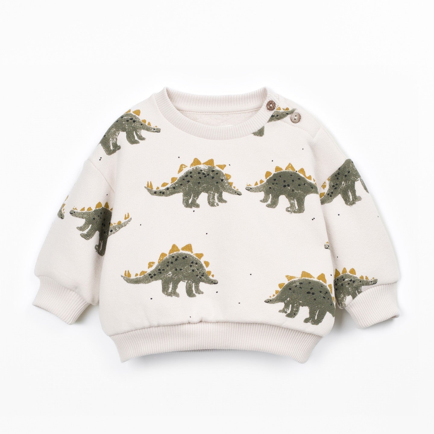 A long-sleeve knit sweater in cream with an all-over print of green and yellow dinosaurs, shown flat on a white background.