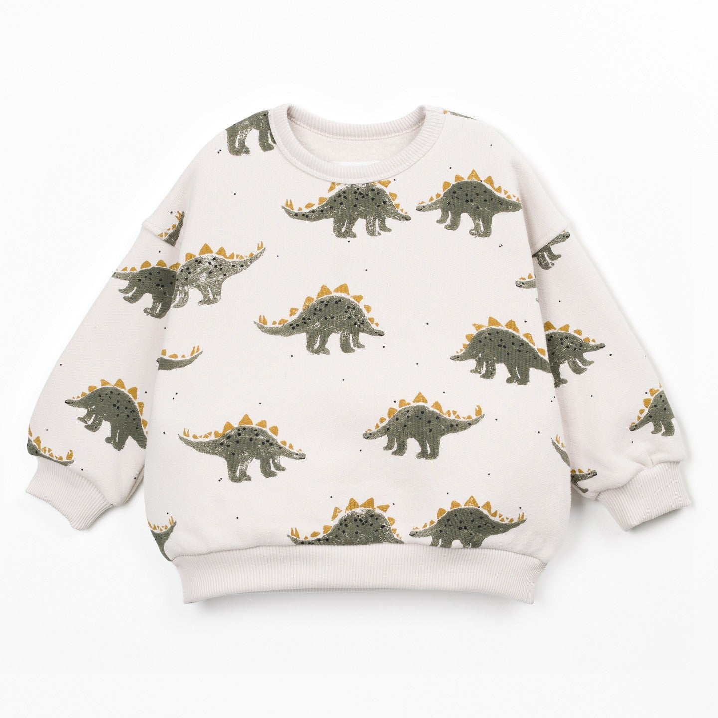 A long-sleeve crewneck sweatshirt for kids, featuring an all-over print of green and brown Stegosaurus dinosaurs with orange-yellow spikes on a warm off-white background.