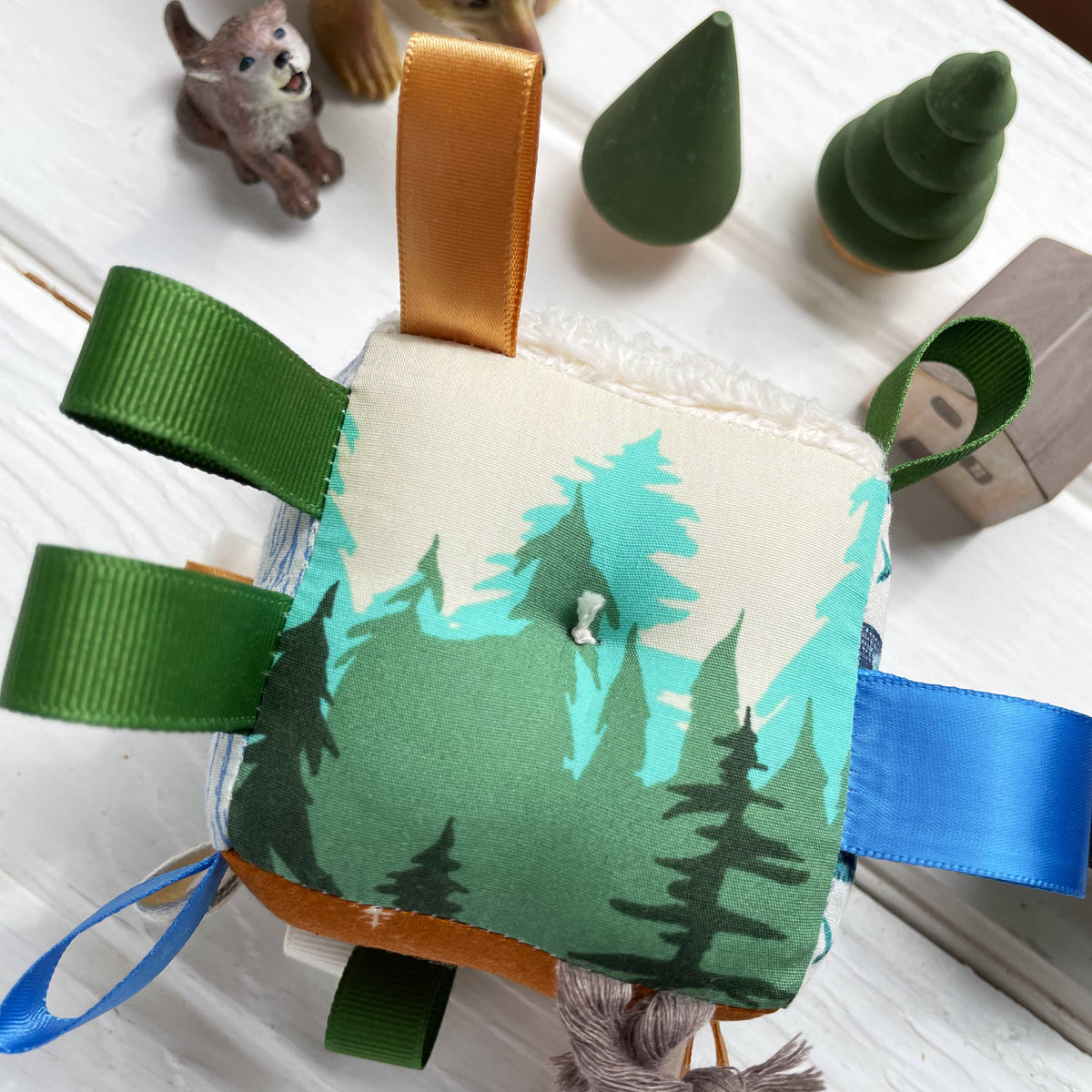 Fabric toy with forest design on a white surface