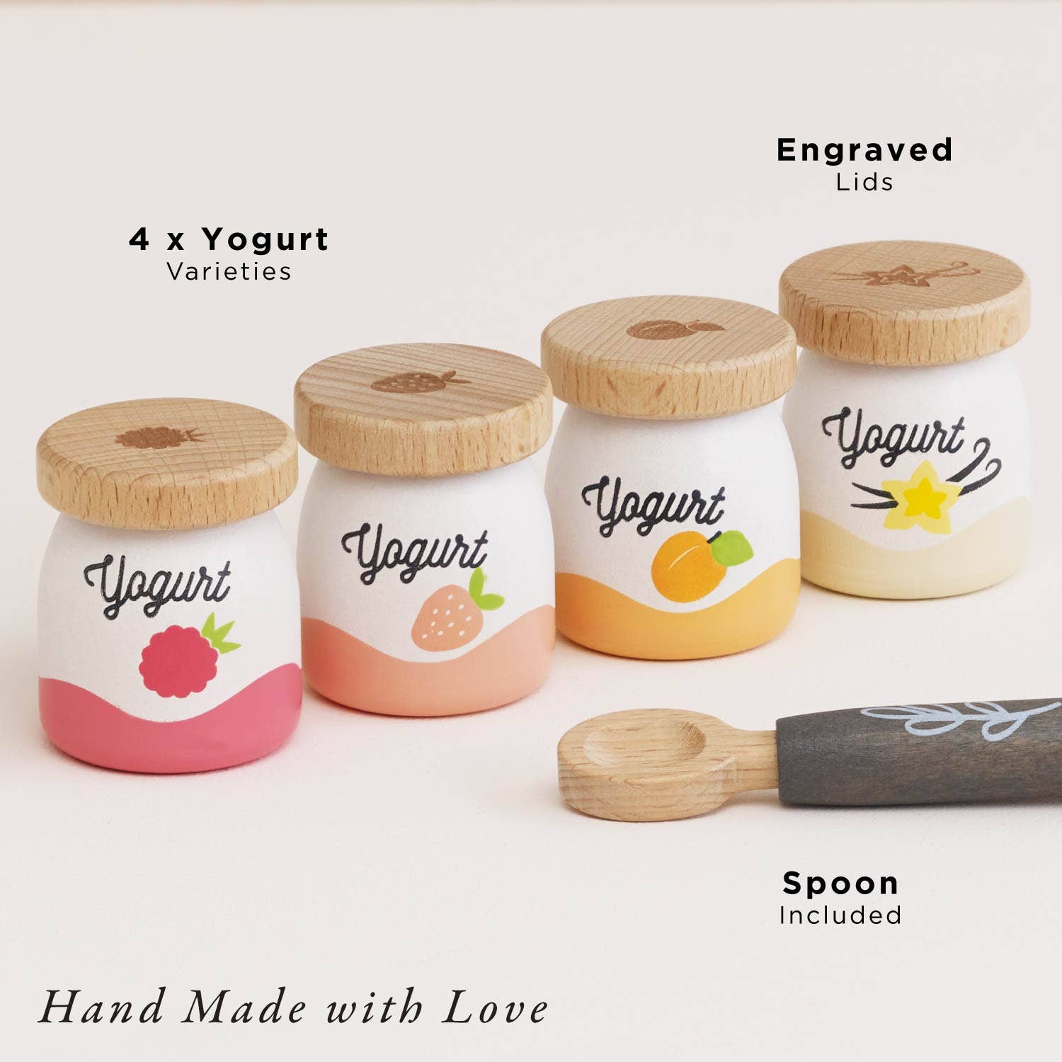 Set of toy yogurt jars with wooden lids and a spoon on a white background
