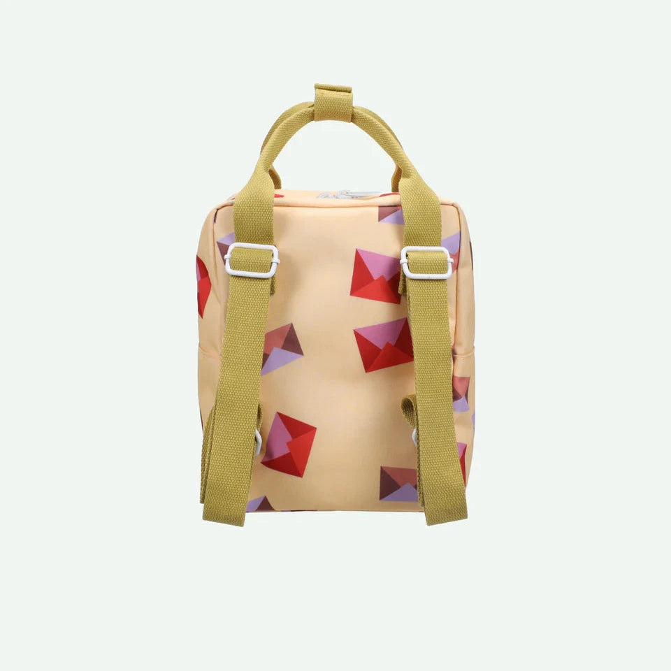 Small beige backpack with colorful geometric pattern on a white background