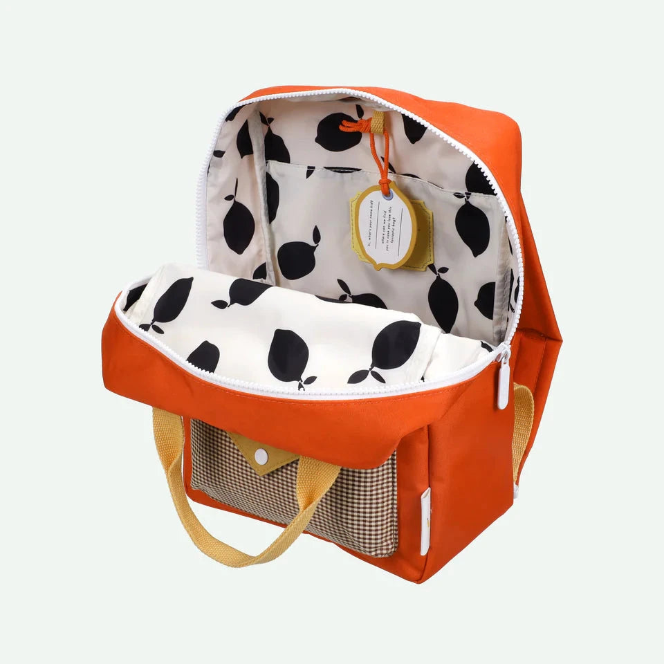 Orange backpack with a polka dot interior on a white background