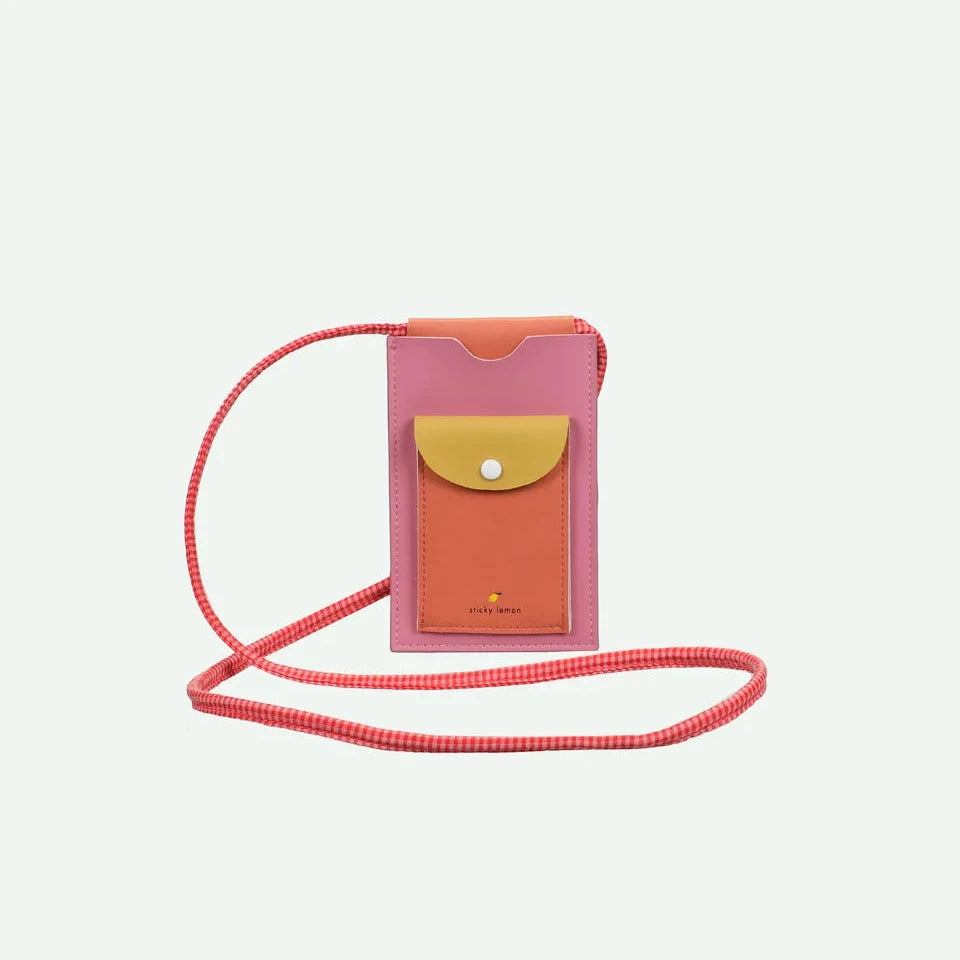 Pink phone pouch with a yellow pocket and red strap on a white background