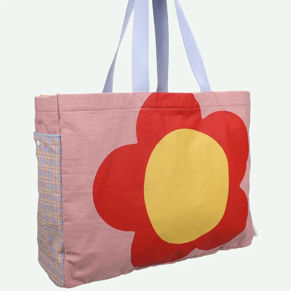 Tote bag with a red flower design on a pink background