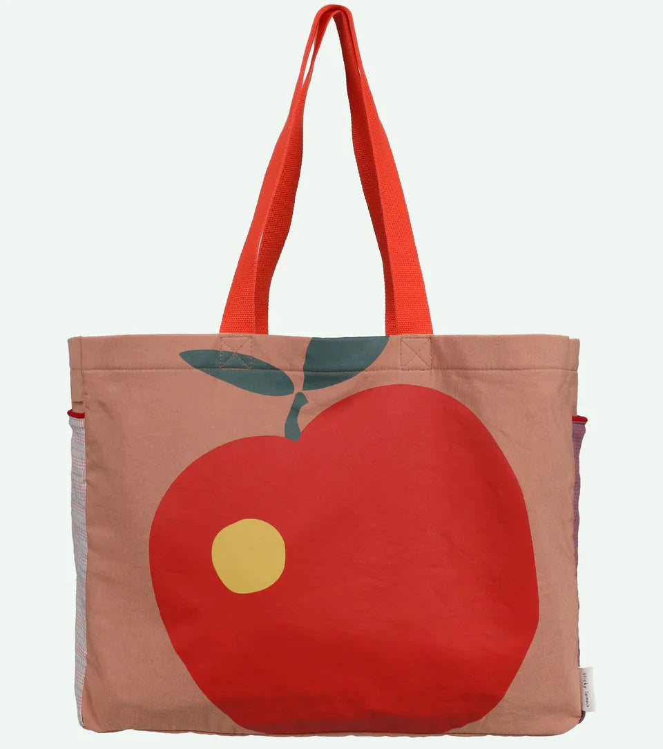 Tote bag with a red apple design on a beige background