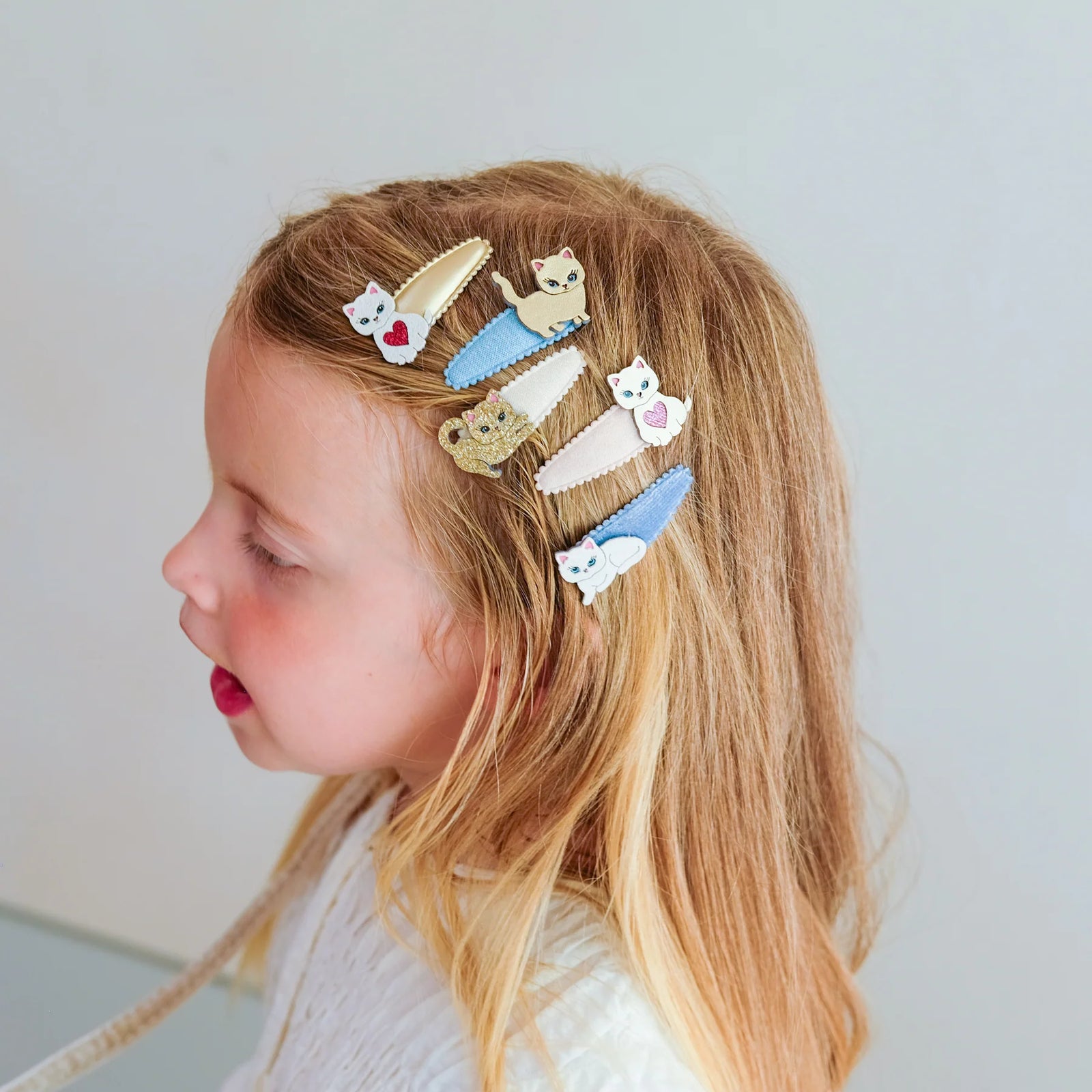 Set of cat-themed hair clips on a white background