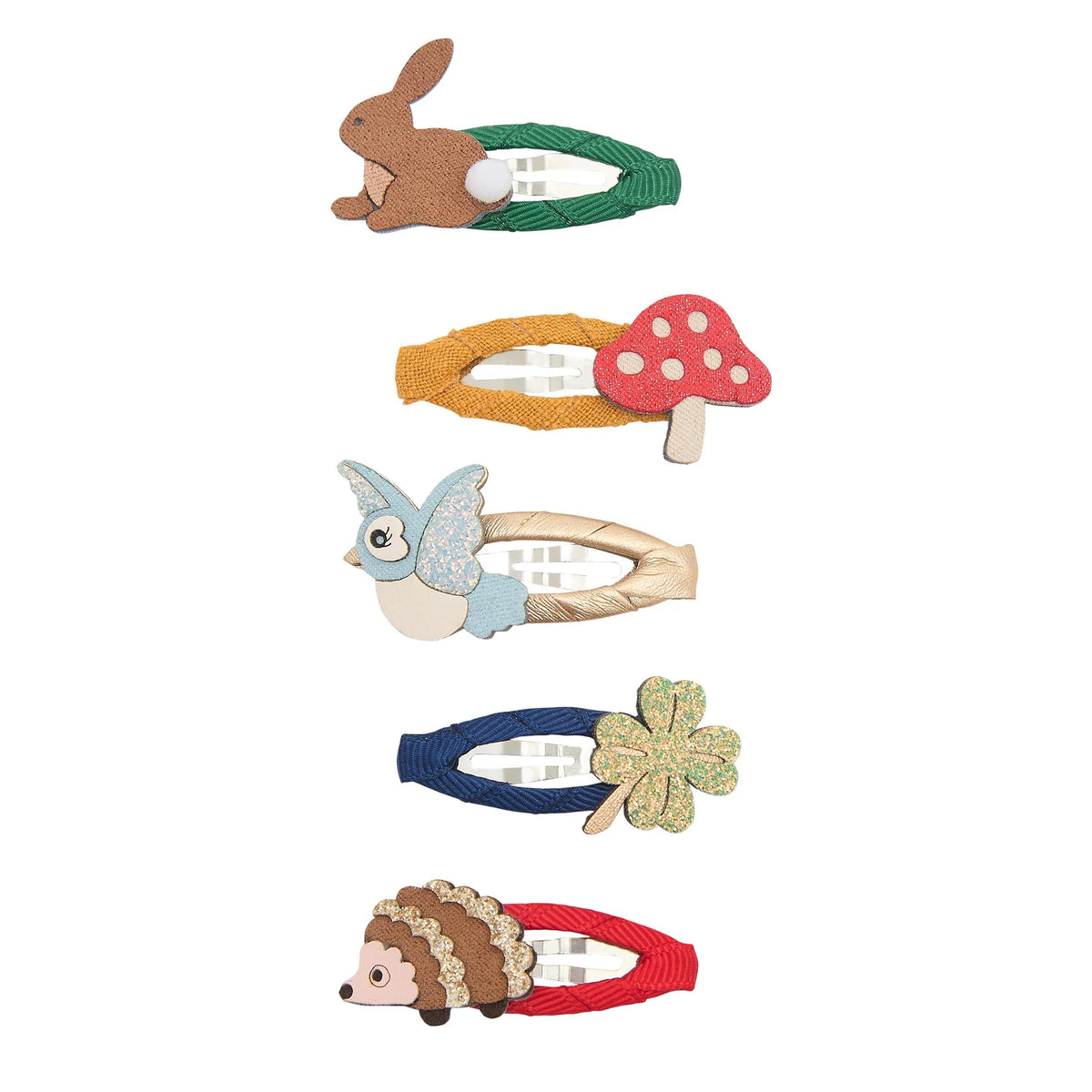 Five children's hair clips arranged vertically on a white background, each shaped like a different animal or object: a rabbit, a mushroom, a bird, a four-leaf clover, and a hedgehog. The clips feature colorful fabric and felt details with elastic bands.