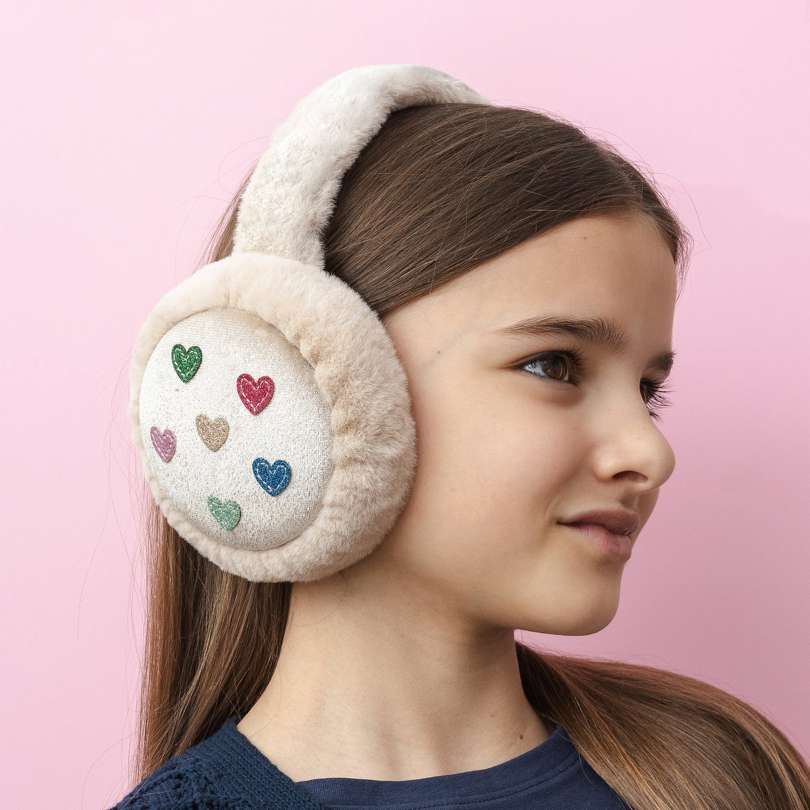 Beige ear muffs with colorful heart designs on a white background