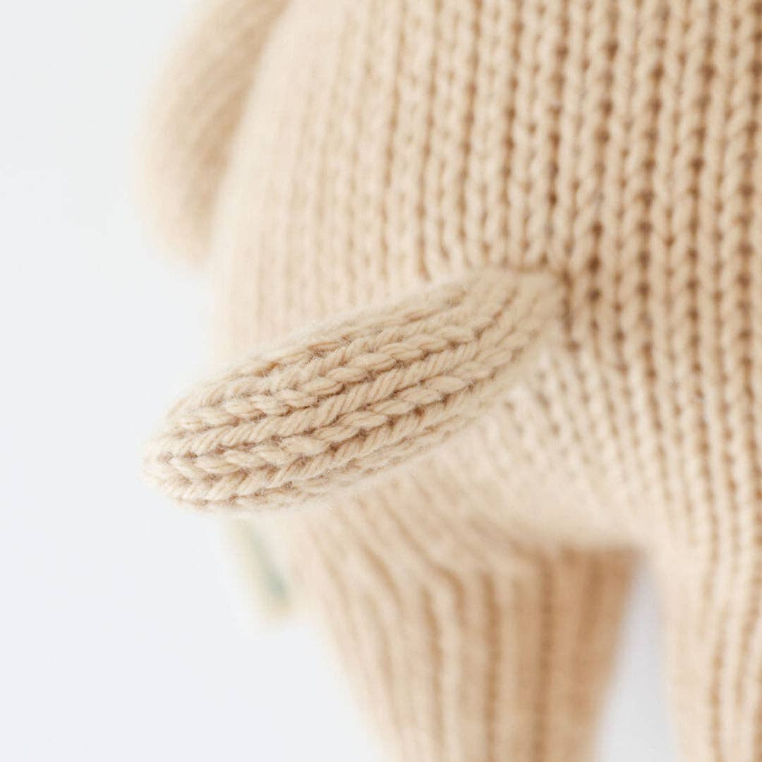 Close-up of beige knitted tail on a light background