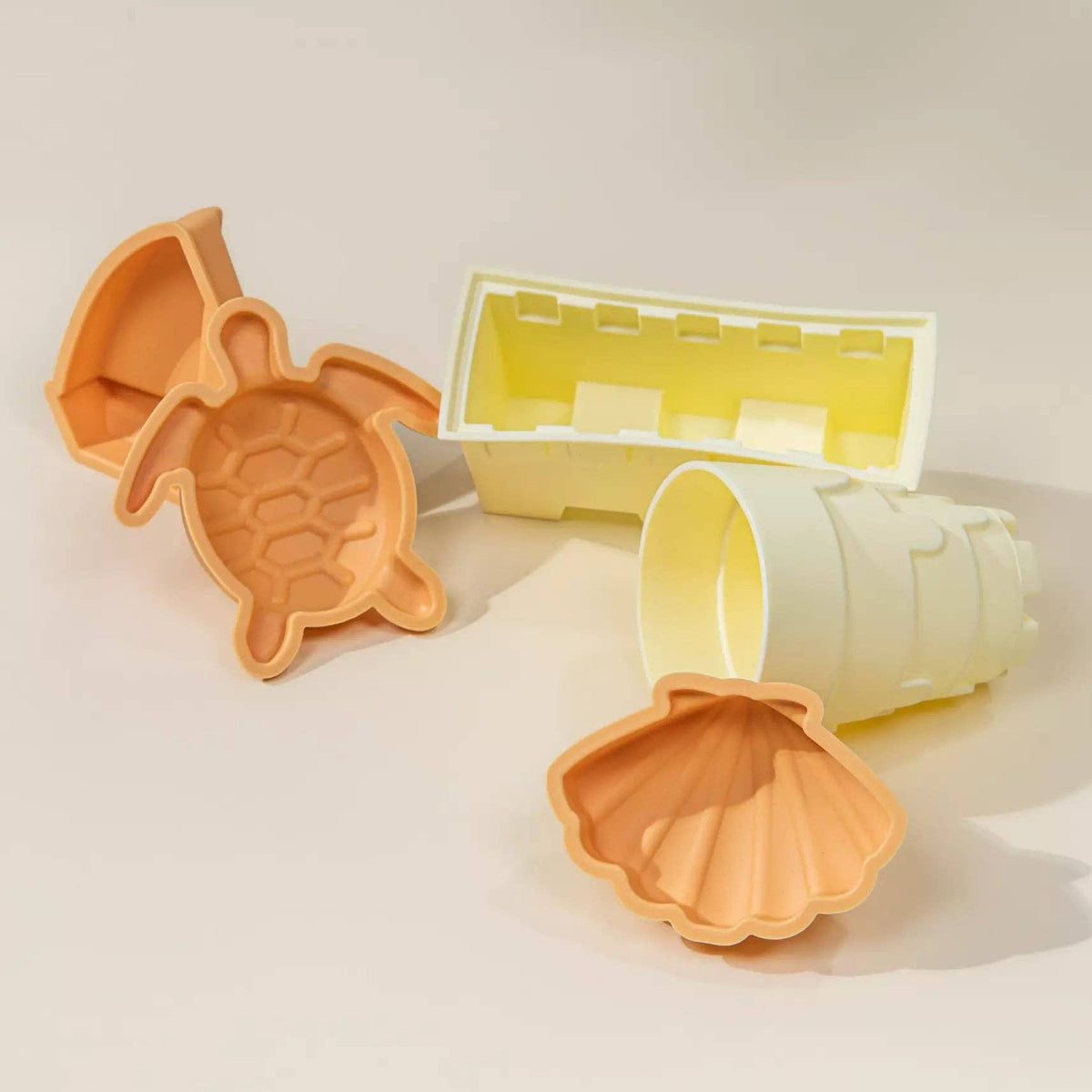 Set of silicone molds shaped like a turtle and a shell on a light background