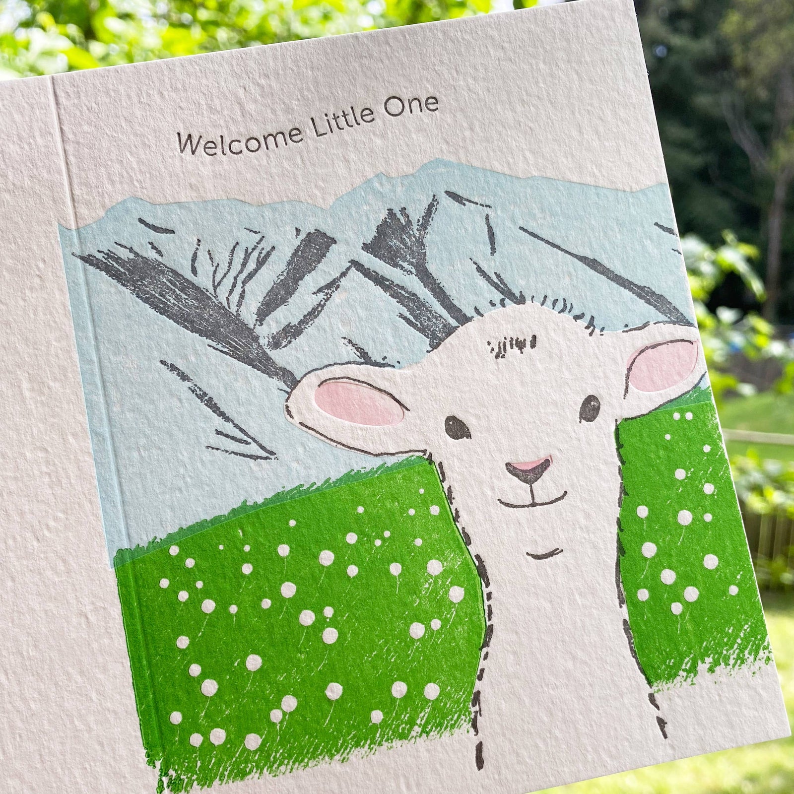Greeting card with a drawing of a lamb and text 'Welcome Little One' on a white background