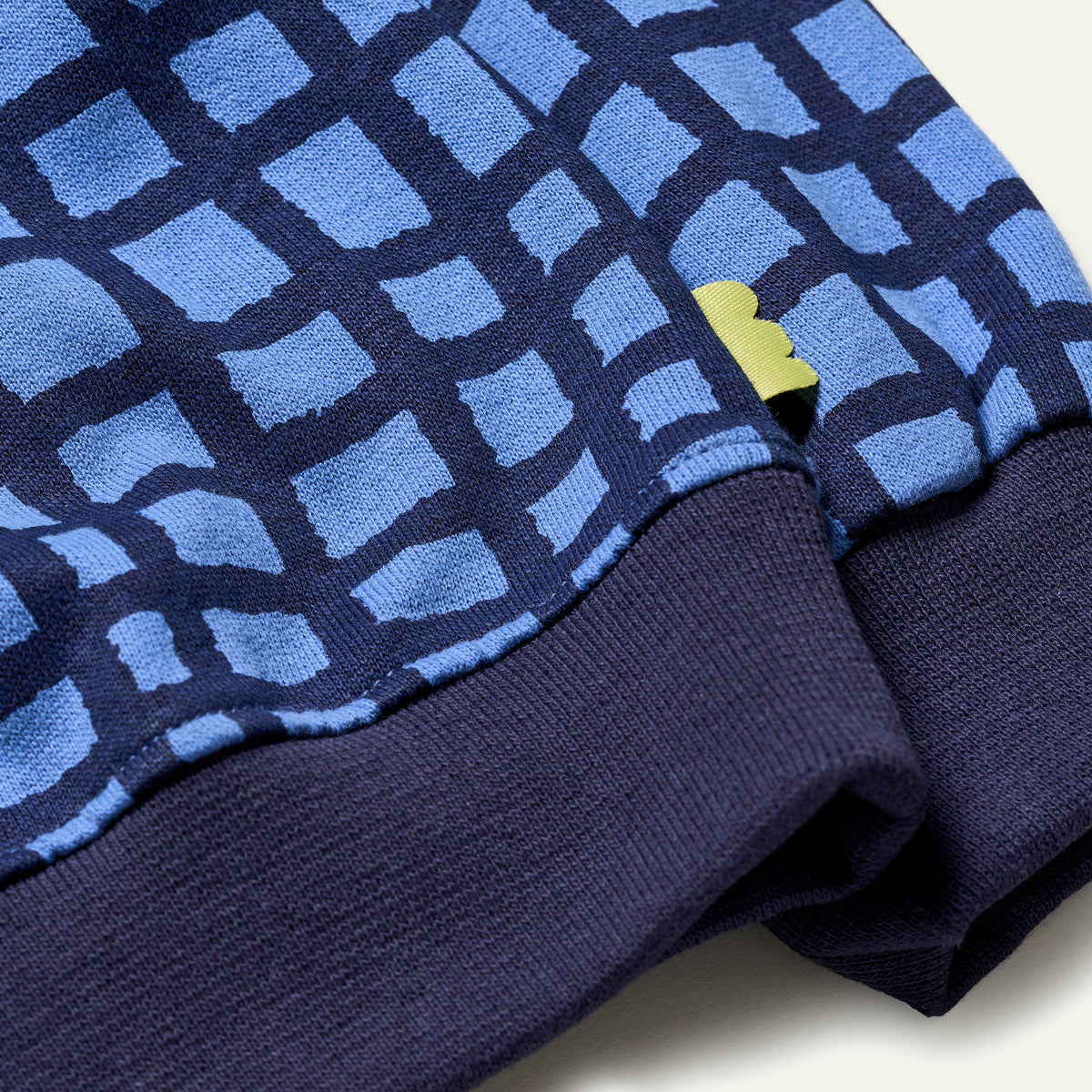 cuff detail of blue grid sweatshirt 