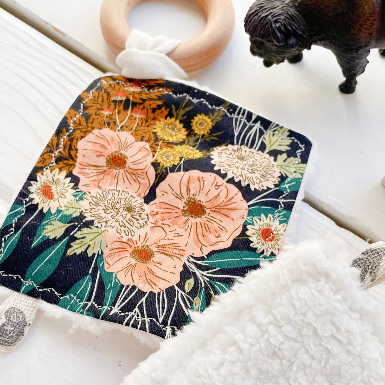 plush crinkle toy with floral pattern and wooden ring