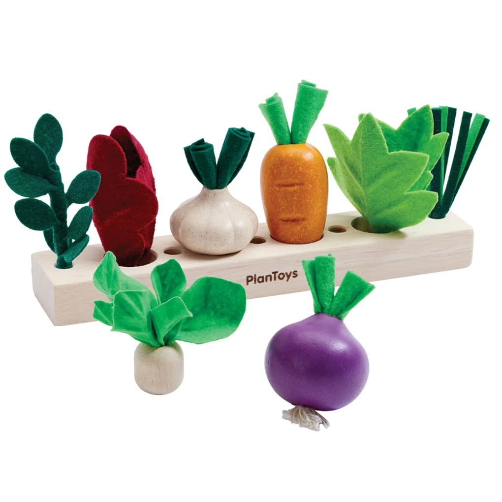 Set of toy vegetables on a wooden stand with PlanToys branding.