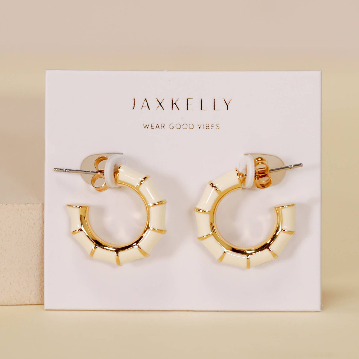 Gold hoop earrings on a JaxKelly branded card with a beige background