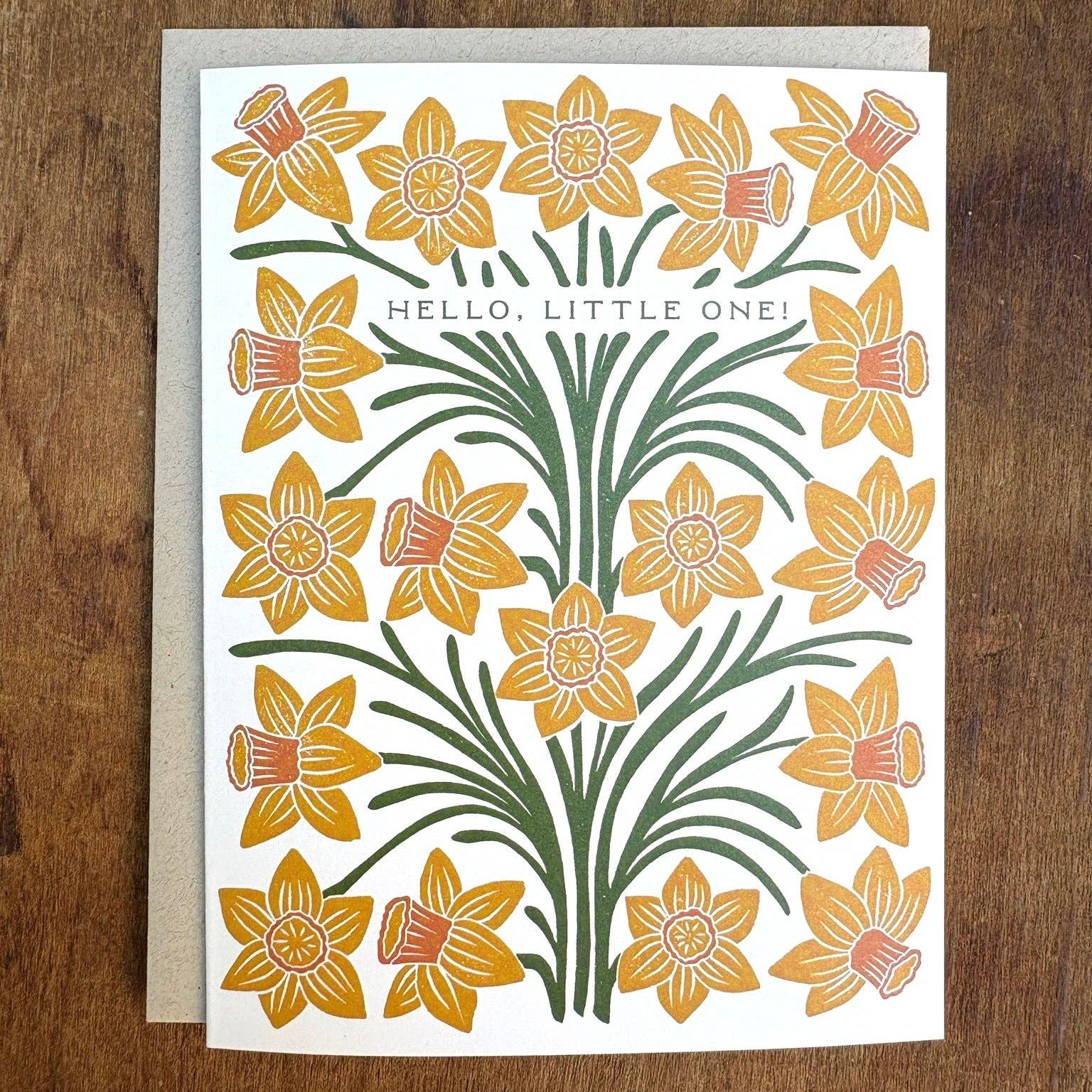 Greeting card with yellow flowers and 'Hello, Little One!' text on a wooden surface