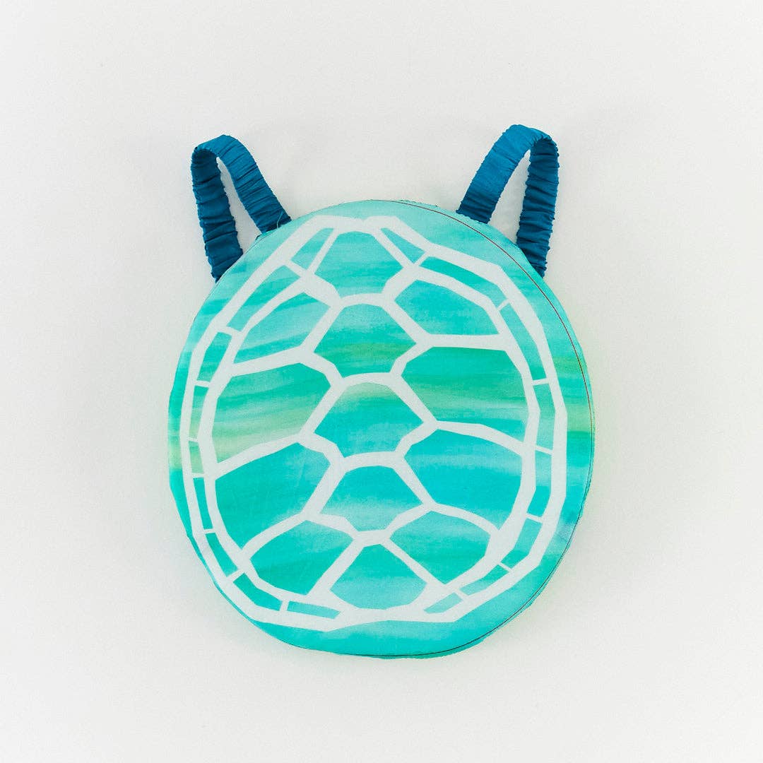 A round, turtle-shaped costume in shades of teal and turquoise with a white painted shell pattern and dark blue handles, shown on a plain white background.