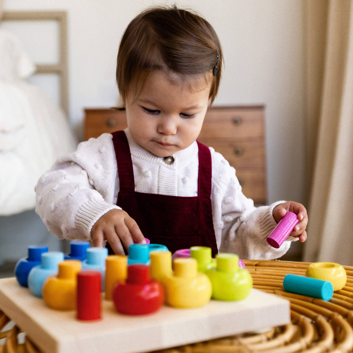 Child playing with colorful wooden toys on a table