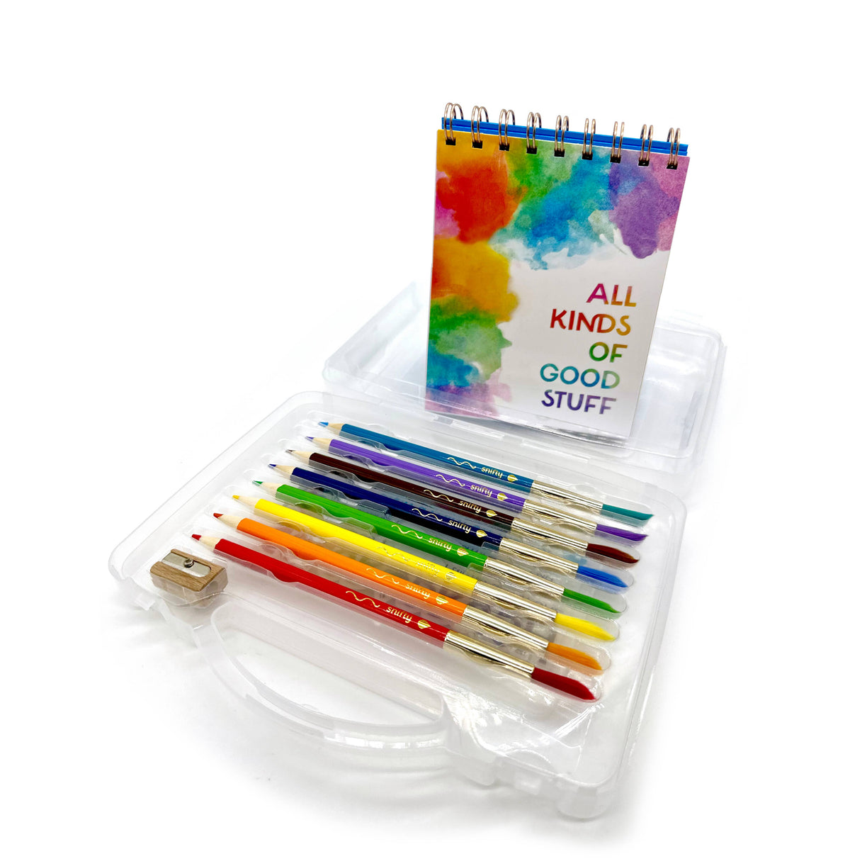 Set of colorful paintbrushes in a clear case with a small notebook titled 'All Kinds of Good Stuff' on a white background.