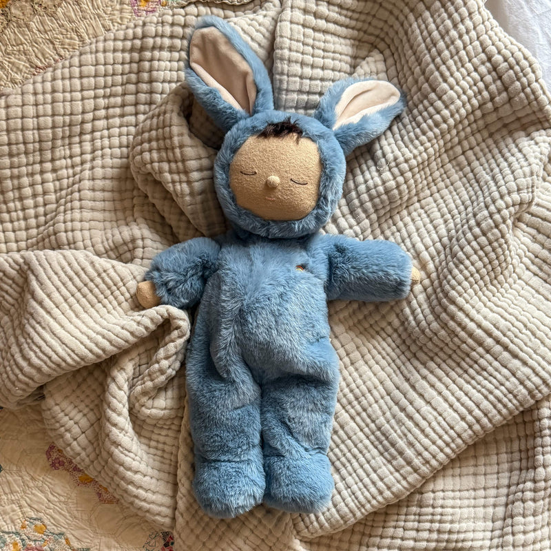 Blue plush toy with bunny ears on a textured beige blanket
