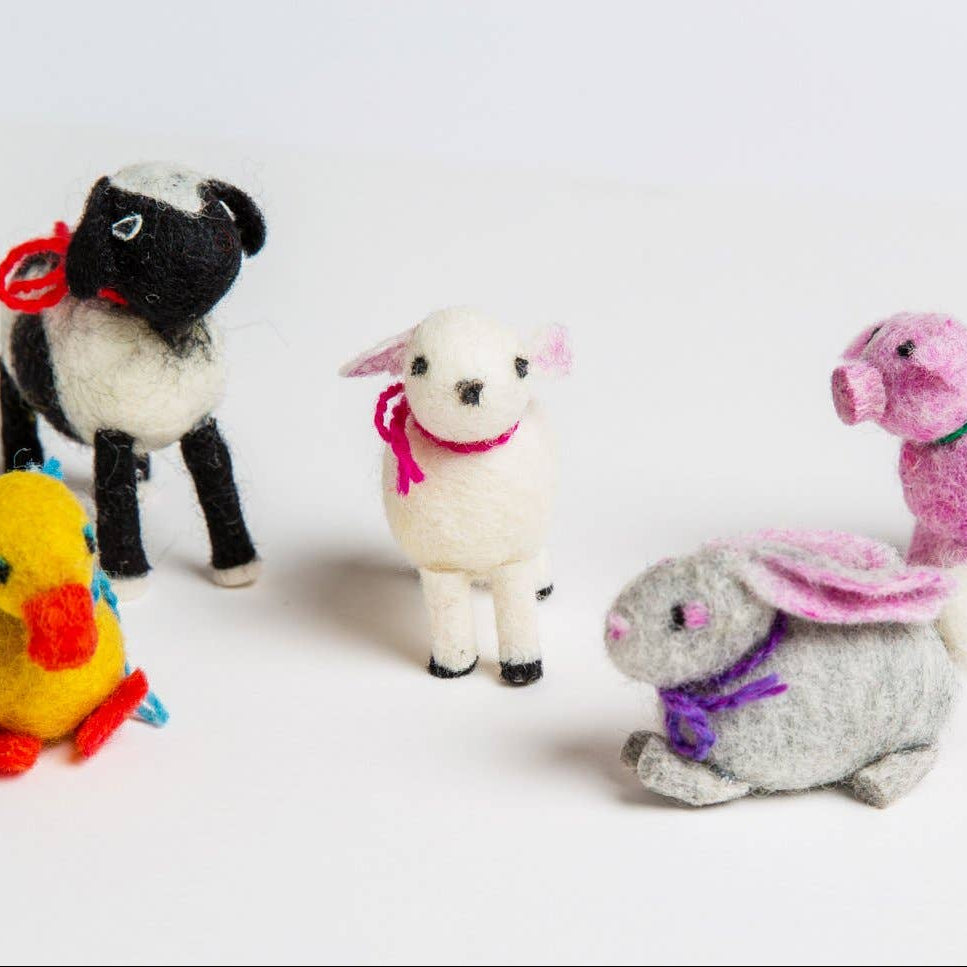 Collection of colorful plush felted animals on a white background